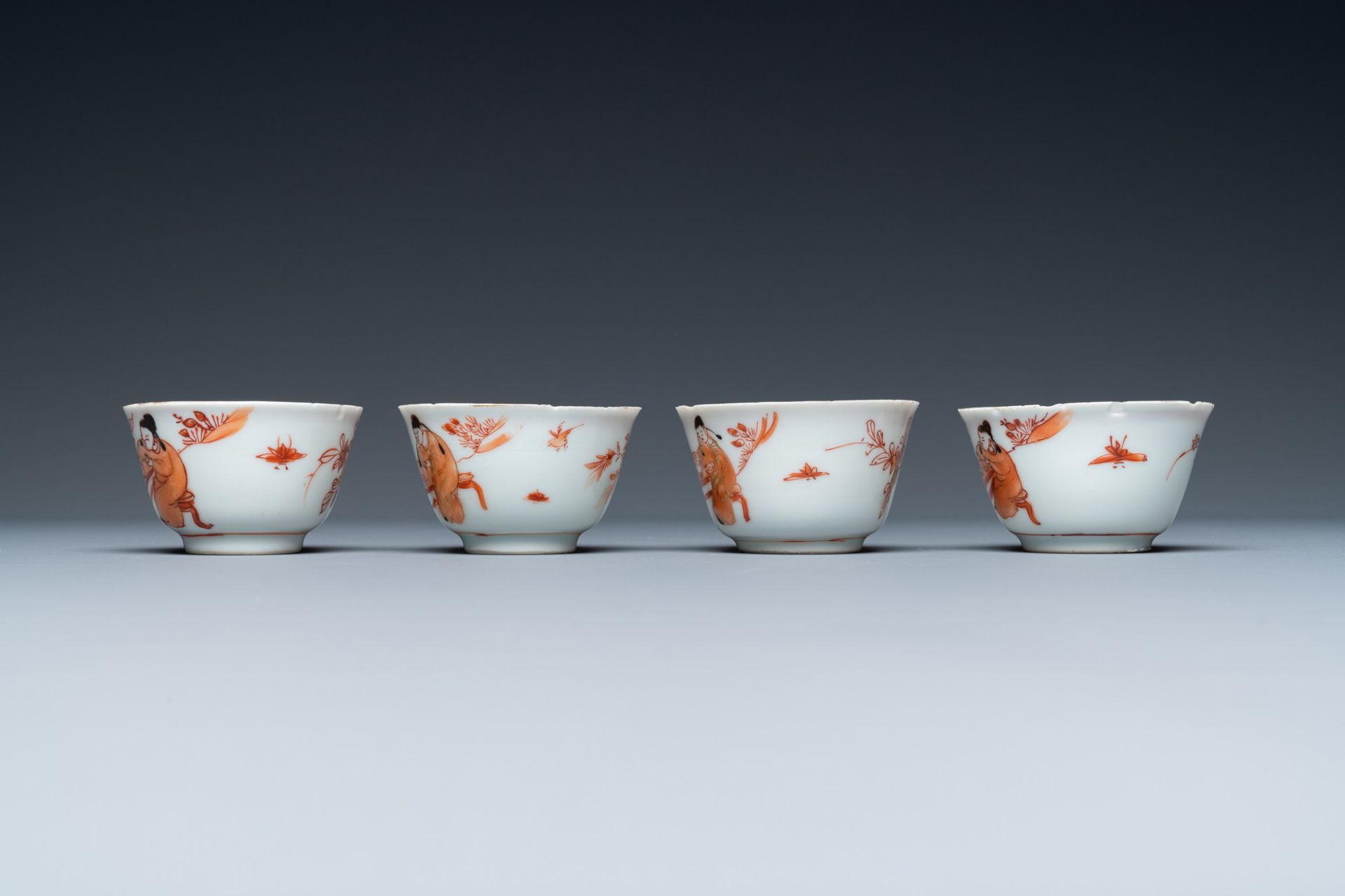 Four Chinese iron-red and gilt cups and saucers with figures near a table, Kangxi - Image 7 of 9