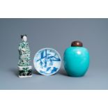 A Chinese verte biscuit figure, a green 'lotus' jar and a figurative blue and white plate, Kangxi an