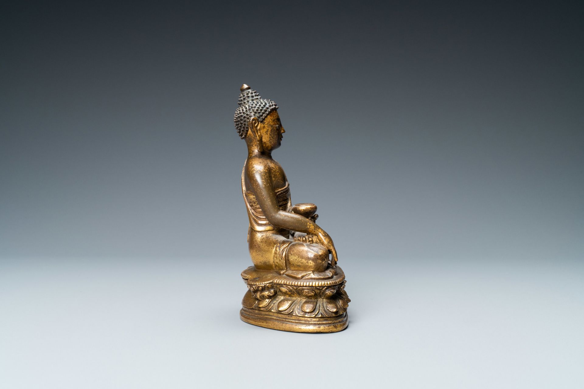 A Chinese gilt bronze 'Medicine Buddha' figure, 17/18th C. - Image 5 of 7