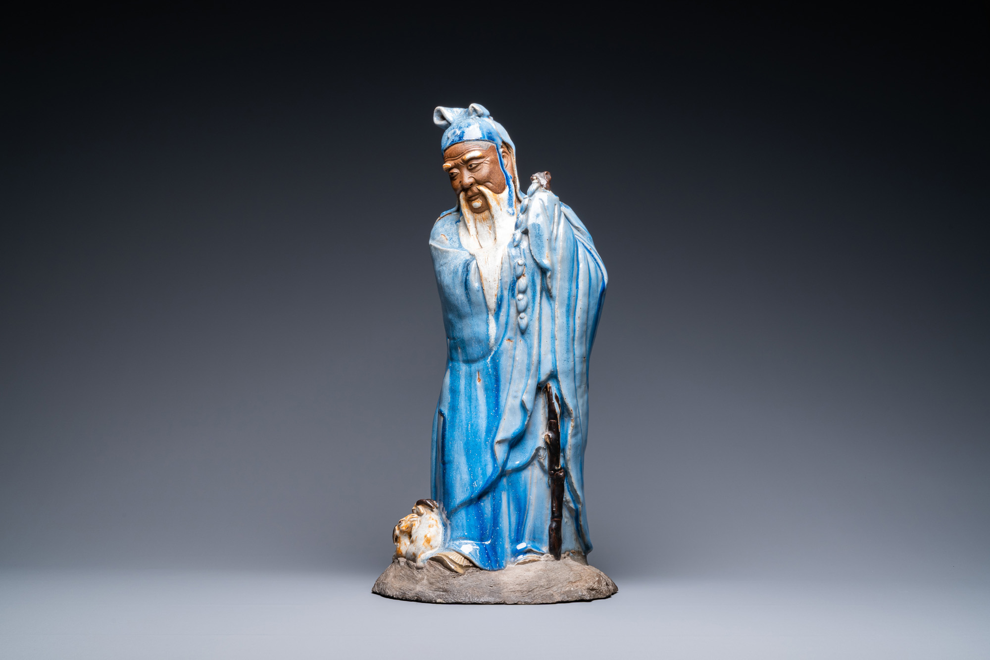 A large Chinese blue-glazed Shiwan pottery 'immortal' figure, 19th C. - Image 2 of 7