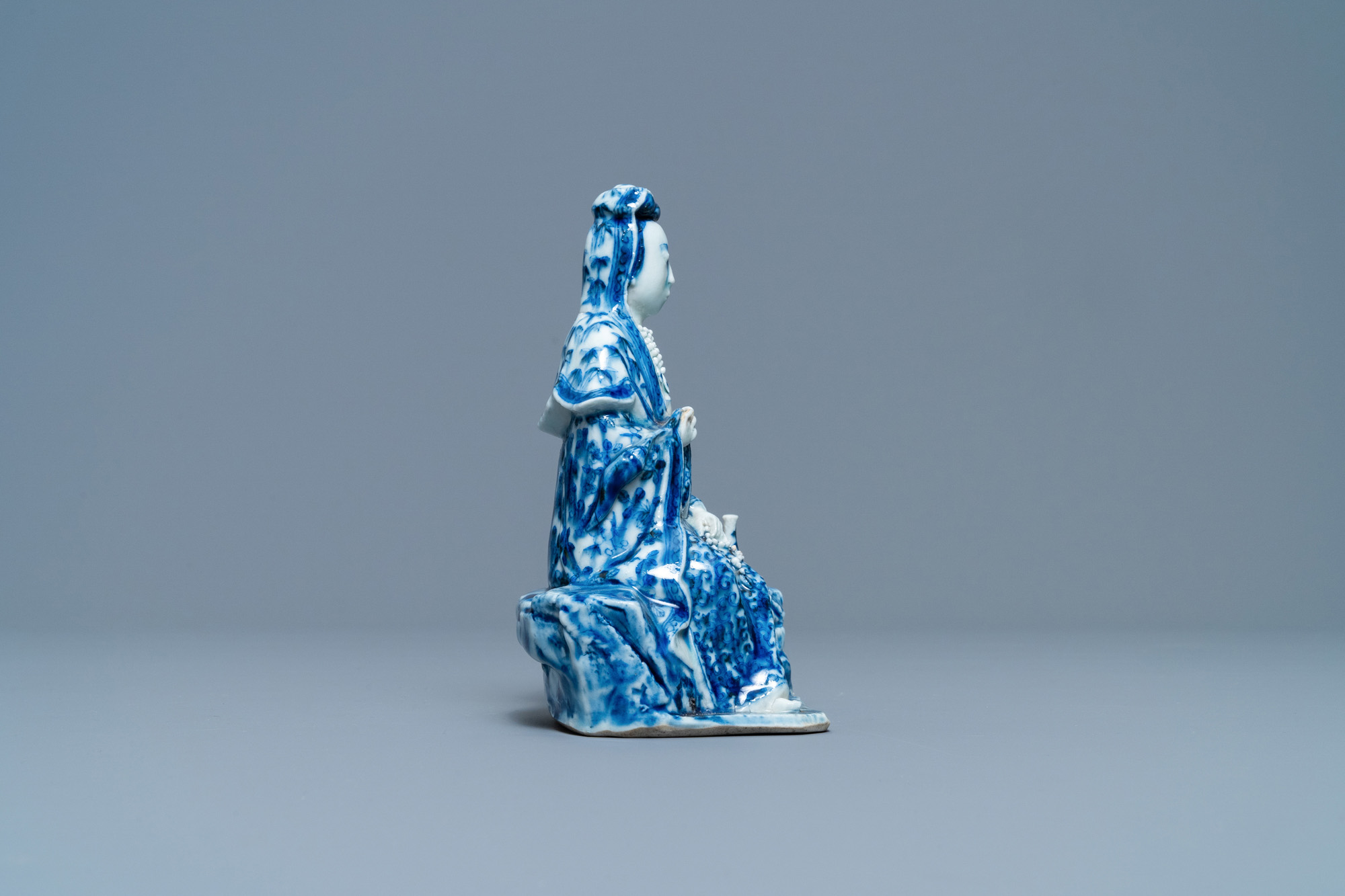 A Chinese blue and white figure of a seated Guanyin, 19th C. - Image 3 of 7
