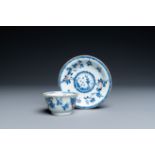 A Chinese blue, white and copper-red cup and saucer, Kangxi