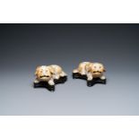 A pair of Chinese porcelain models of reclining dogs, Qianlong/Jiaqing