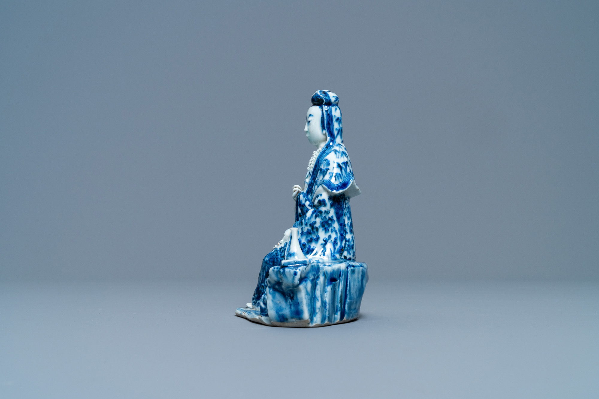 A Chinese blue and white figure of a seated Guanyin, 19th C. - Image 5 of 7