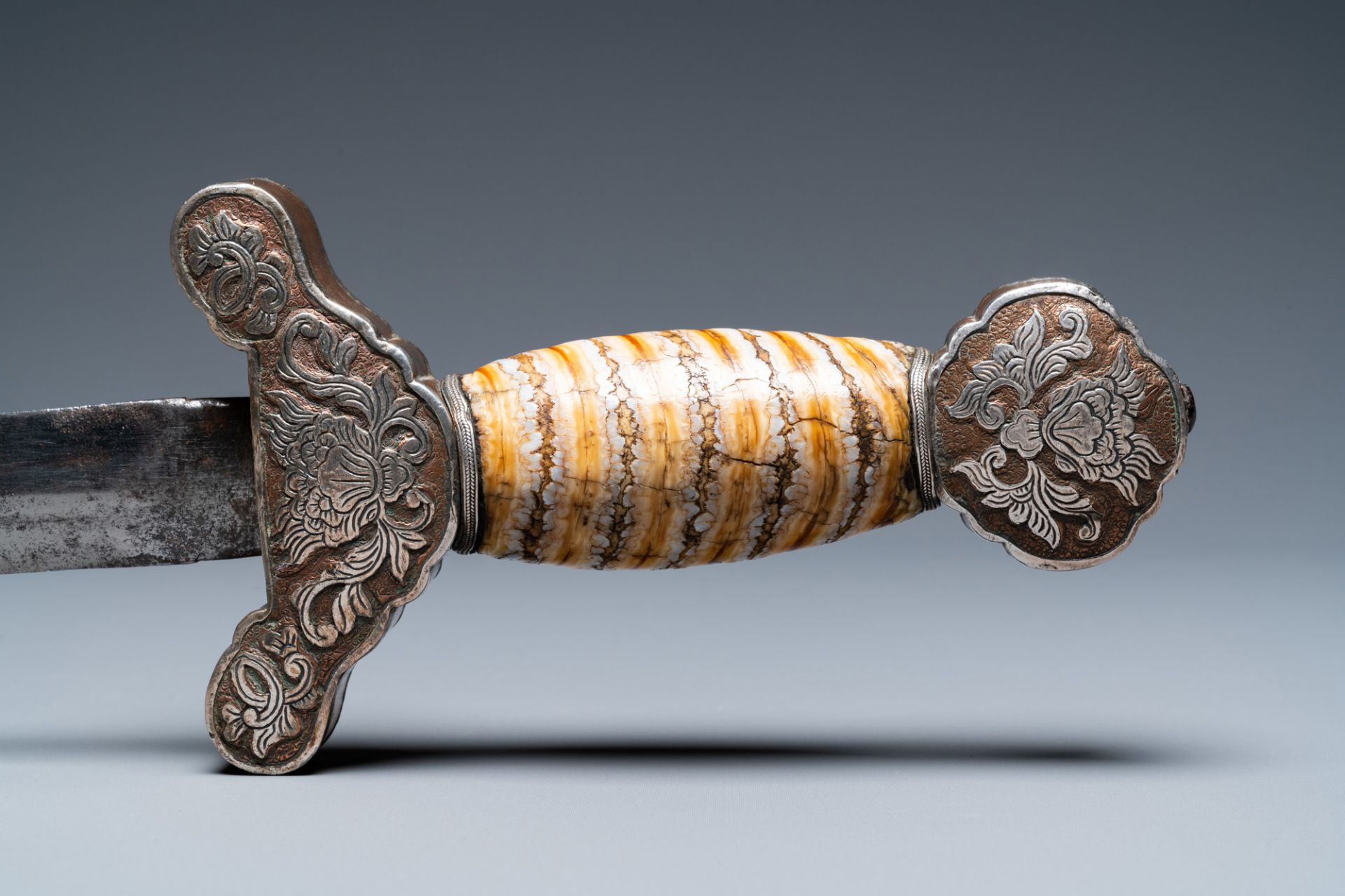 A Tibetan steel sword with silvered copper and mammoth tooth hilt, 19th C. - Image 7 of 7