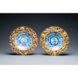 A pair of Chinese blue and white plates in Chinese gilded wooden frames, Kangxi and 19th C.