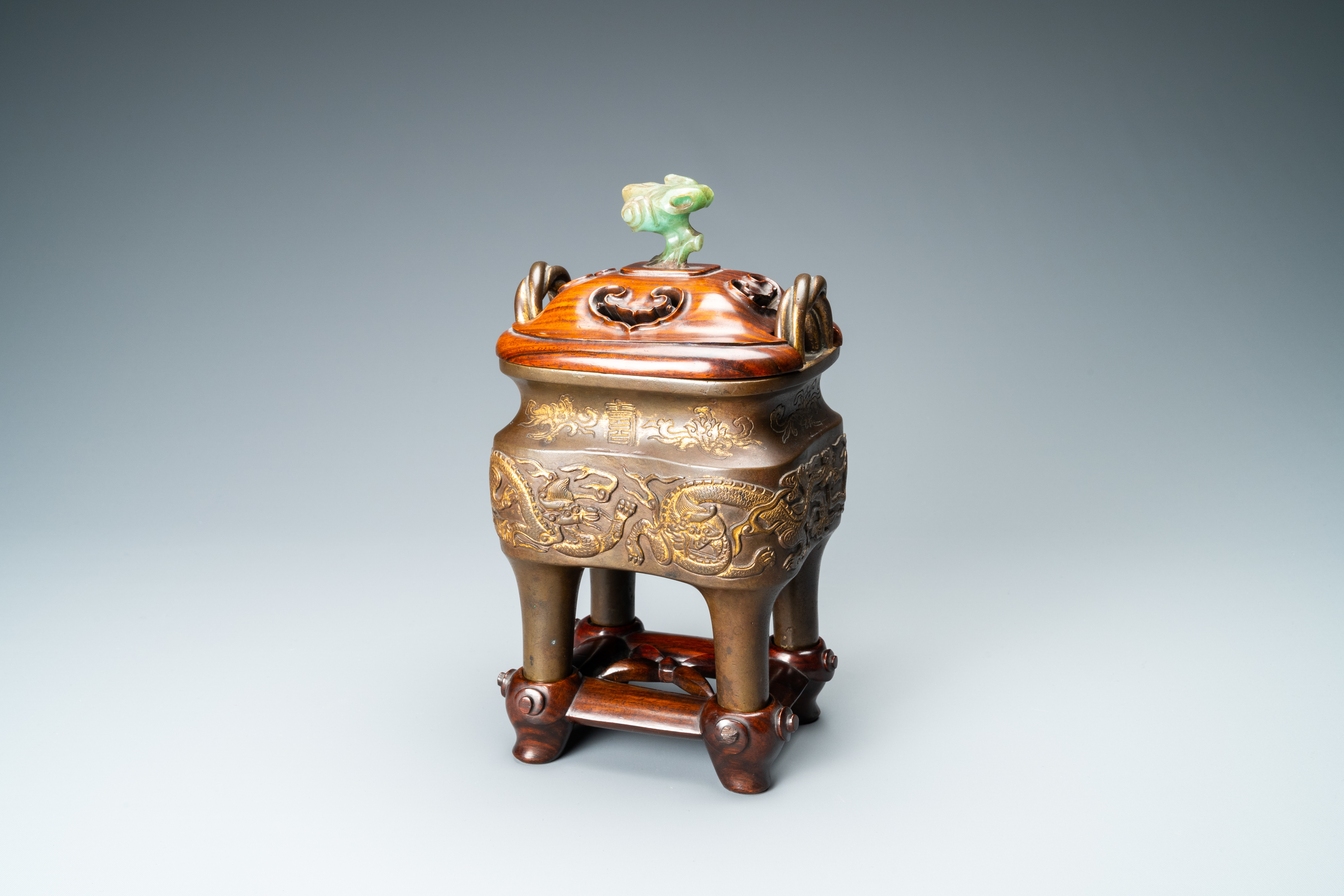 A Chinese partly gilded bronze censer with jade-topped wooden cover, Xuande mark, Kangxi