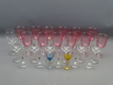 SET OF TWELVE CRANBERRY TINTED WINE GLASSES on plain columns and bases, a set of seven plain wine