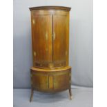 MAHOGANY TWO-PIECE BOW FRONT STANDING CORNER CABINET having twin doors and drawers to the upper
