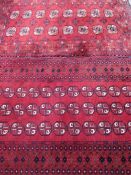 EASTERN STYLE WOOLLEN CARPETS (2) both red ground and similarly patterned multi-block central panels