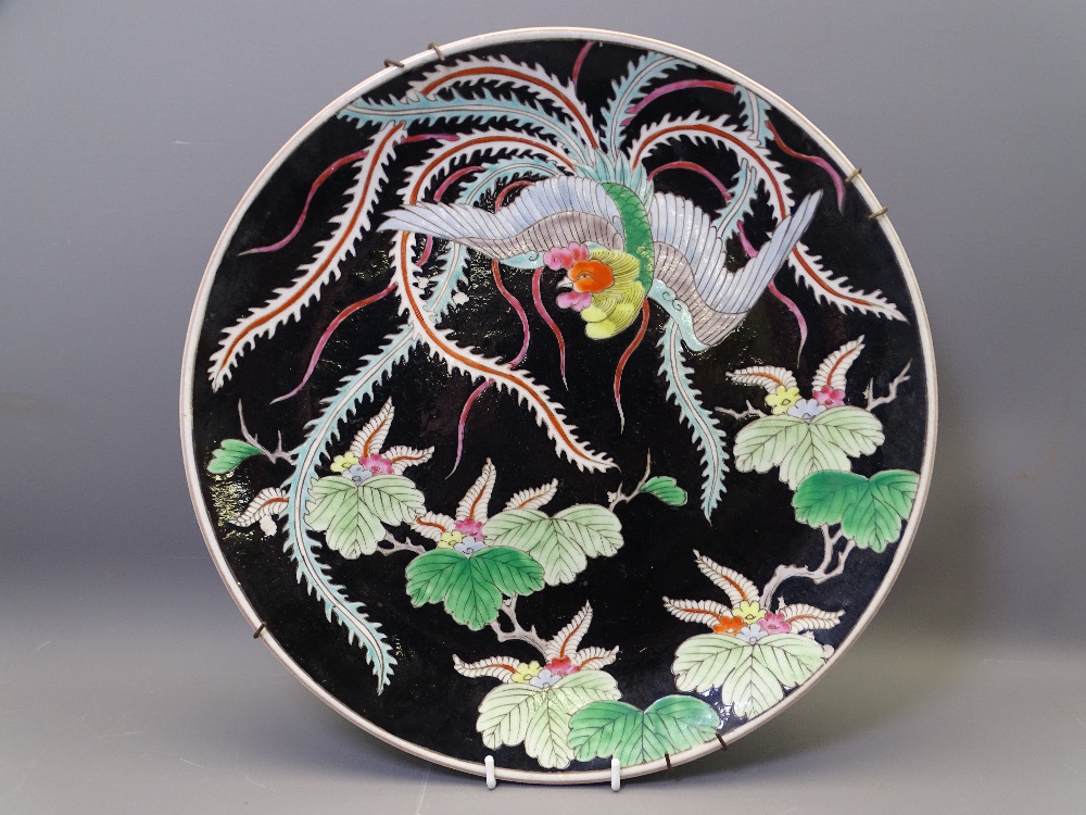 ORIENTAL CHARGER - a late 19th/early 20th century black ground charger with floral and bird