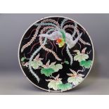 ORIENTAL CHARGER - a late 19th/early 20th century black ground charger with floral and bird