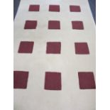 ULTRA MODERN WOOLLEN RUG, cream ground with repeated multiple square pattern, wine colour insets,