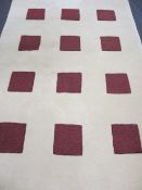 ULTRA MODERN WOOLLEN RUG, cream ground with repeated multiple square pattern, wine colour insets,