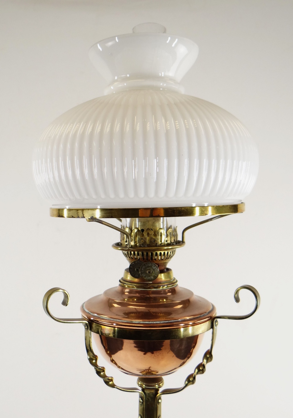 ARTS & CRAFTS BRASS AND COPPER STANDARD OIL LAMP, with foliate decorated tripod base and column,