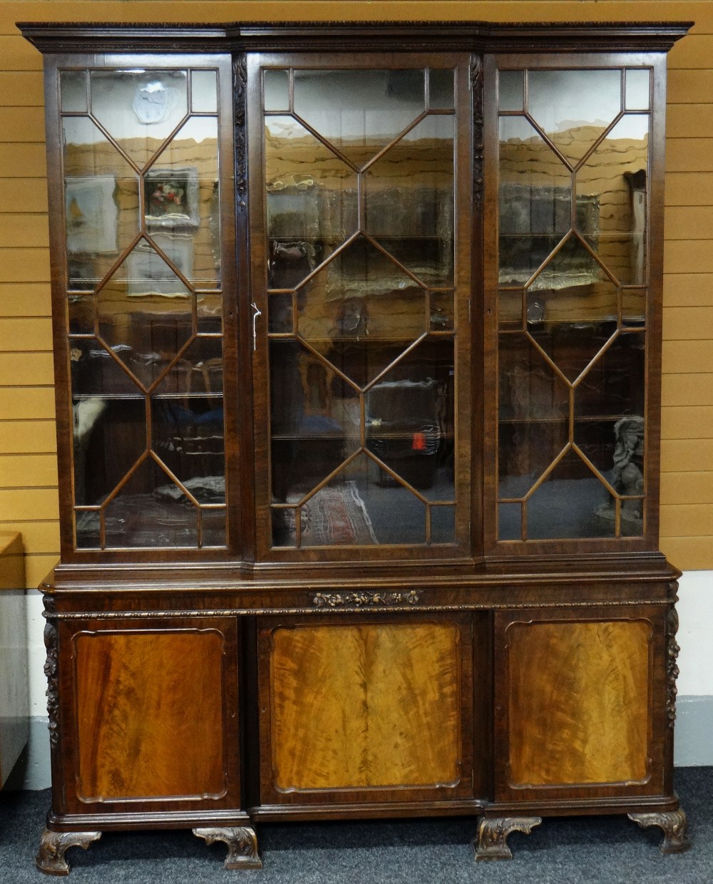 FINE WARING & GILLOW MAHOGANY BREAKFRONT BOOKCASE, foliate carved cavetto cornice above astragal