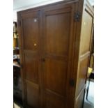 COTSWOLD SCHOOL STYLE OAK WARDROBE with moulded doors and cast iron butterfly hinges, 177cms high