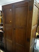 COTSWOLD SCHOOL STYLE OAK WARDROBE with moulded doors and cast iron butterfly hinges, 177cms high