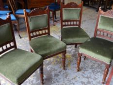 FOUR LATE VICTORIAN WALNUT DINING CHAIRS with carved cresting rails, spindle backs, stuff over