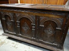 17TH CENTURY-STYLE OAK COFFER, panelled moulded top above arch carved triple panelled front, moulded