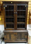 NIGEL GRIFFITHS STAINED OAK BOOKCASE, with leaded and glazed doors on cupboard base, 92 x 152cms