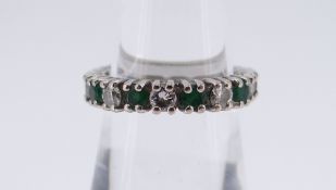 18CT WHITE GOLD, EMERALD & DIAMOND HALF ETERNITY RING comprising eight emeralds and seven