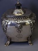 SILVER NEAR SQUARE TEA CADDY with applied floral and leaf decoration, hinge lid on four scrolled