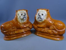 STAFFORDSHIRE RECUMBENT LIONS, A PAIR, 28cms and 29cms