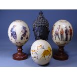 OSTRICH EGGS (3) transfer decorated with military and Zulu scenes and a cast bronze Eastern bust