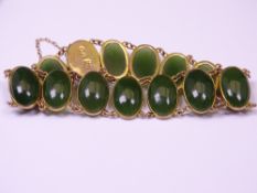 A 9CT GOLD BRACELET with 15 oval cabochon Jadeite style, 18.5grms gross