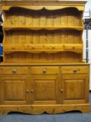 PINE DRESSER with shaped frieze over two shelves, the lower with four small drawers, the base