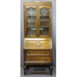 VINTAGE OAK BUREAU BOOKCASE having twin upper leaded glass doors and interior shelves over a