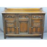 QUALITY CARVED OAK RAILBACK SIDEBOARD having three frieze drawers and lower cupboard doors on