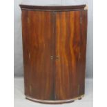 CIRCA 1840 MAHOGANY BOW FRONT WALL HANGING CORNER CUPBOARD, 103cms H, 68.5cms W (some moulding