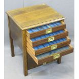 VINTAGE OAK FOUR DRAWER COIN COLLECTOR'S CABINET, the drop-down front opening to reveal four glass