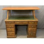 TWIN PEDESTAL DESK with a leather tooled top, two banks of four and one long central drawer and drop