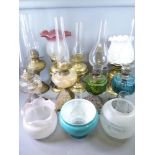 OIL LAMPS - several brass, iron based with coloured reservoirs, a quantity of etched and other