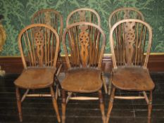 A SET OF SIX ELM WINDSOR CURVED BACK SPINDLE CHAIRS each with centre wheelback and turned supports