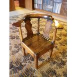 ANTIQUE ELM CORNER FARMHOUSE ELBOW CHAIR having a curved back with twin shaped splats and turned