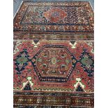 TWO EASTERN WOOLLEN CARPETS, red and blue ground with central block pattern and multi-bordered edge,