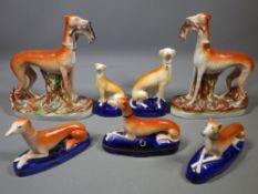 STAFFORDSHIRE POTTERY GREYHOUNDS FIGURES GROUP including a standing pair having captured hares