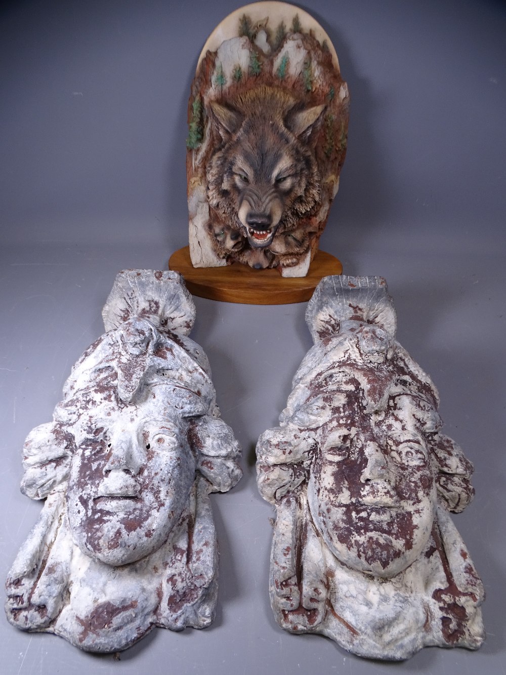 LEAD WALL PLAQUES, a pair depicting Greek military heads, 44cms H, and a Canadian wolf model by Paul