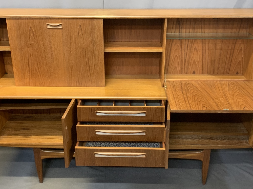 MID-CENTURY LONG TEAK SIDEBOARD with drop down top cupboards and central shelf over three central - Image 2 of 4