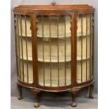 EDWARDIAN MAHOGANY SERPENTINE FRONT CHINA DISPLAY CABINET with single central door, fabric covered