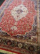 KASHMIR TABRIZ-STYLE CARPET, artificial silk, with ivory medallion and pendants on a shaped red