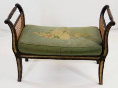 REGENCY-STYLE EBONISED WINDOW SEAT, caned scrolled sides and seat, later cushion, 82cms wide