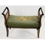 REGENCY-STYLE EBONISED WINDOW SEAT, caned scrolled sides and seat, later cushion, 82cms wide