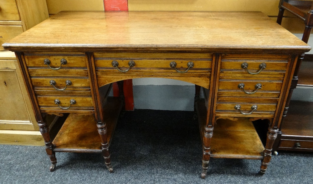 LATE VICTORIAN MAHOGANY KNEEHOLE DESK, fitted seven drawers on turned legs, tied by platform