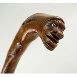 19TH CENTURY PROVINCIAL FOLK ART WALKING STICK, the naturally curved handle carved with a head