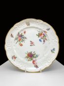A NANTGARW PORCELAIN DESSERT PLATE of lobed form, the border moulded with c-scrolls and reserved